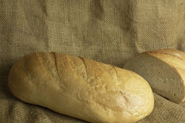 Çuval bezi arka planında taze el yapımı ekmek