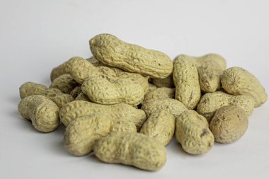 Beyaz arka plandaki çiğ fıstıklardan bir avuç dolusu.