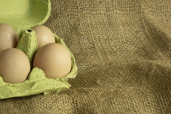 paper box with farm fresh chicken eggs on sackcloth background