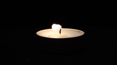 koyu arka plan üzerinde yanan mum.