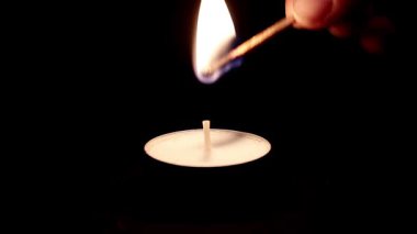 koyu arka plan üzerinde yanan mum.