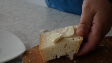 Kadınlar ekmeğe yağ sürer.