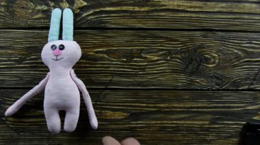 Ahşap bir arka planda oyuncak peluş tavşan