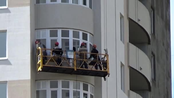 Pracovník maluje barvu na výškových budovách. — Stock video