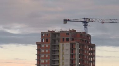 Bulutlar hızlı hareketli arka plan üzerinde inşaat vinç