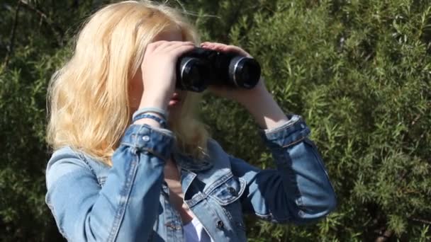 Fille regardant à travers les jumelles — Video