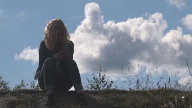 Bir tepede oturan kız