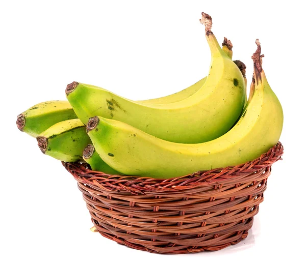 Many green bananas in brown wicker basket isolated on white — Stock Photo, Image