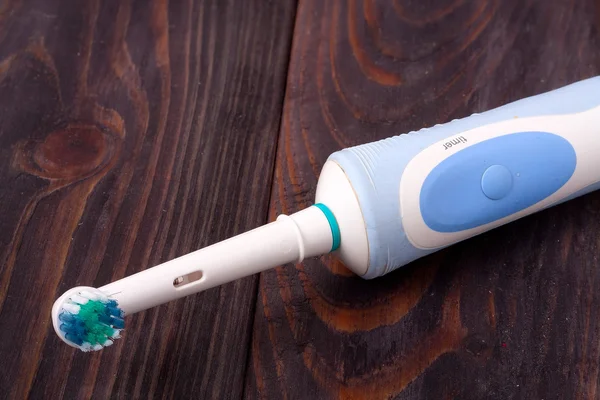 The old electric toothbrush on wooden background — Stock Photo, Image