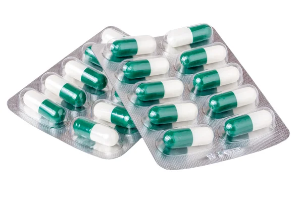 白い背景の赤い緑黄色錠剤と 2 つのパッケージ — ストック写真