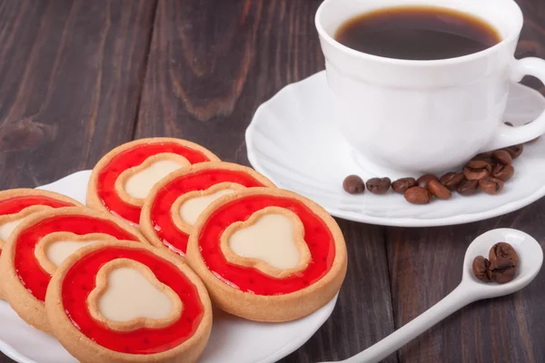 Kaffekopp med bönor och cookies på tabellen trä — Stockfoto