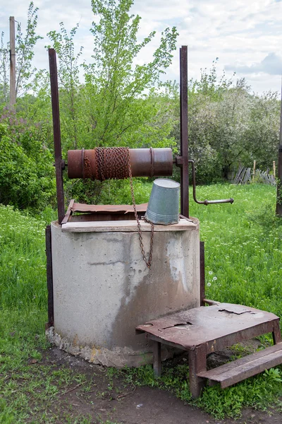 Old well with water in the village — Stock Photo, Image