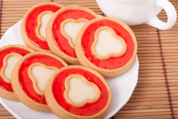 Soubory cookie s želé a šálek kávy na ubrousek bambus — Stock fotografie