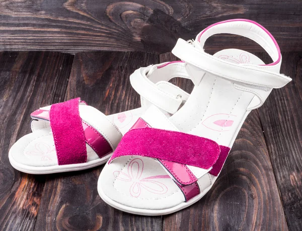 Childs sandals on a dark wooden background — Stock Photo, Image