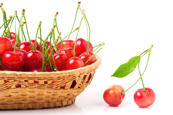 Cerezas rosadas en una canasta de mimbre aislada sobre fondo blanco —  Fotos de Stock