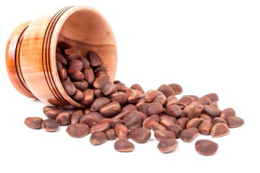 Beyaz arka plan üzerinde ahşap bir varil içinde soyulmamış sedir fındık