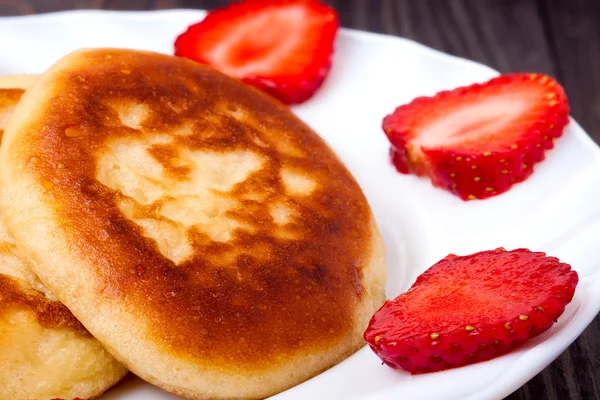 Krapfen auf einem Teller mit Erdbeeren Holzhintergrund — Stockfoto