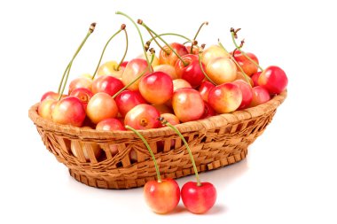 Beyaz arka plan üzerinde izole bir hasır sepet içinde sarı kiraz
