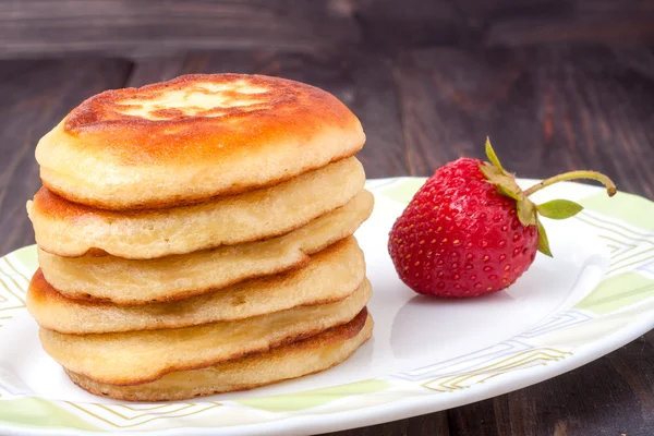 Buñuelos en un plato con fresas aisladas fondo blanco — Foto de Stock