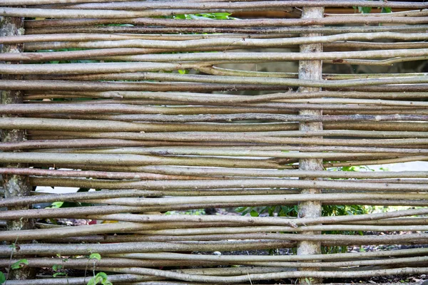Деревянный плетеный забор из палок в сельской местности — стоковое фото