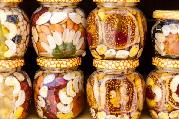 Домашний мед с сухофруктами и орехами на рынке — стоковое фото