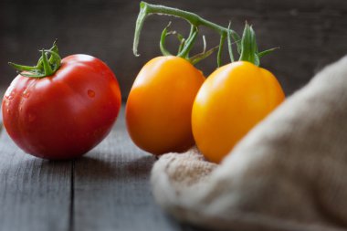 Çul bir tahta masada üç domates