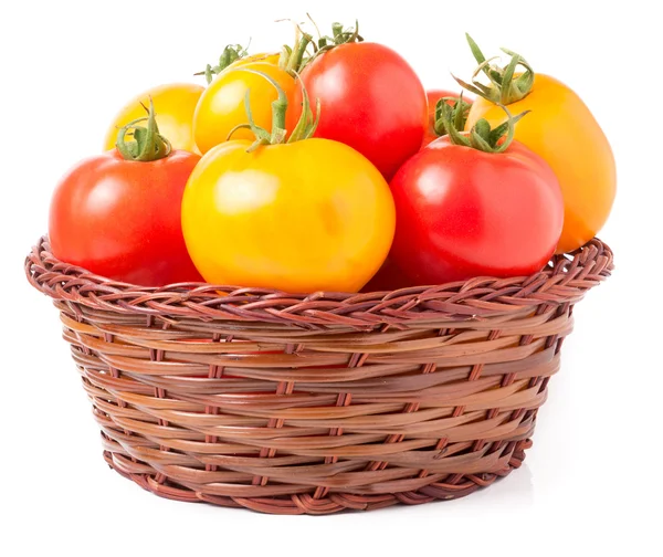 Red and yellow tomatoes in a wicker basket isolated on white background — Stock Photo, Image