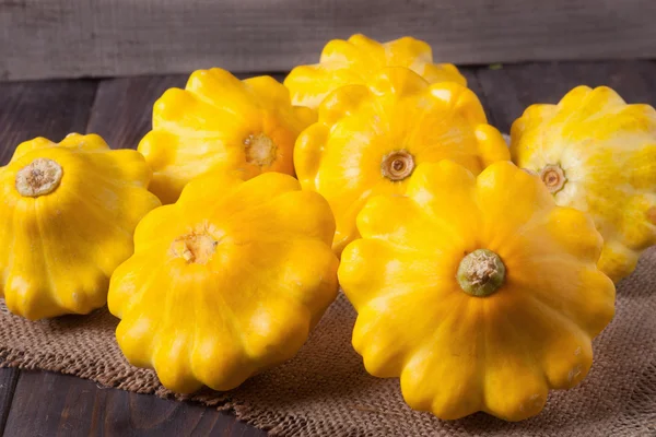 yellow squash on a wooden background with  napkin of burlap