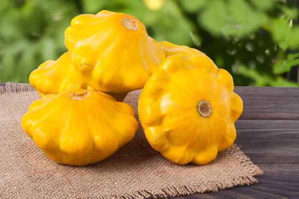 Courge jaune sur un fond en bois avec serviette de toile de jute — Photo