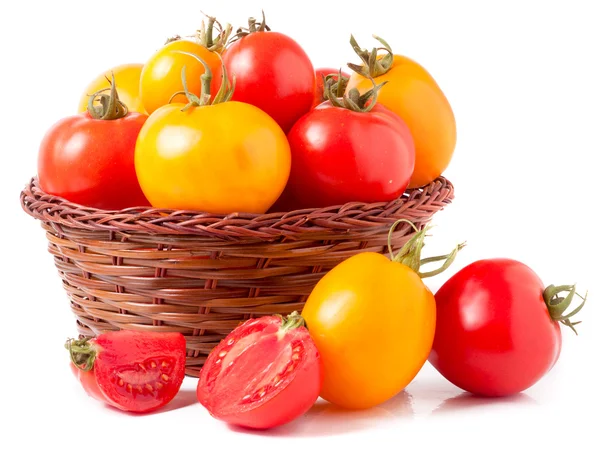 Red and yellow tomatoes in a wicker basket isolated on white background — Stock Photo, Image