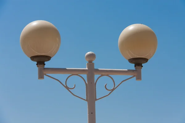 Lâmpada de rua redonda no fundo azul céu — Fotografia de Stock