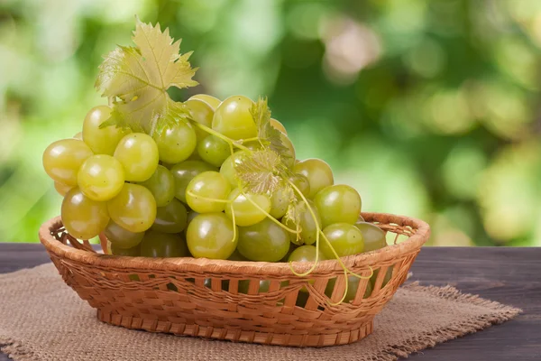 Arka plan bulanık bir tahta masada olgun Yeşil üzüm demet — Stok fotoğraf