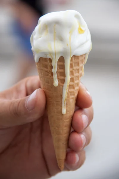 Ice cream cone melting in a mans hand — Stock Photo, Image