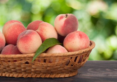 Şeftali bir hasır sepet arka plan bulanık ahşap tablo