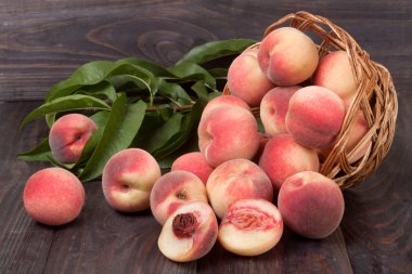 ahşap masa üzerinde bir hasır sepet şeftali