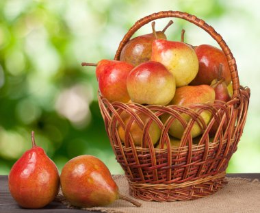 arka plan bulanık ile ahşap masa üzerinde bir hasır sepet armut