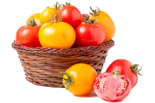 Red and yellow tomatoes in a wicker basket isolated on white background — Stock Photo, Image