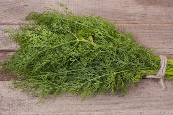 Bunch of dill on wooden background — Stock Photo, Image