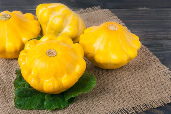 Calabaza amarilla sobre fondo de madera con servilleta de arpillera —  Fotos de Stock