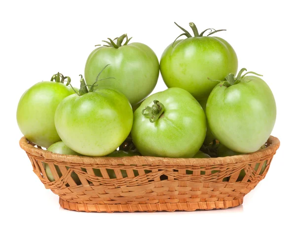 Unreife grüne Tomaten in einem Weidenkorb isoliert auf weißem Hintergrund — Stockfoto