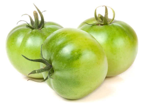 Три зеленых незрелых помидора на белом фоне — стоковое фото