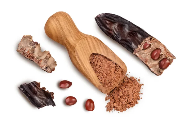 Carob pod and powder in wooden scoop isolated on white background with clipping path. Top view. Flat lay — Stock Photo, Image