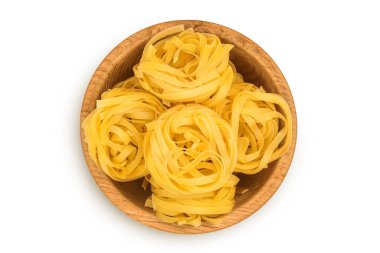 Tahta kasede çiğ tagliatelle makarna. Beyaz arka planda izole edilmiş. Kırpma yolu ve geniş bir alan. Üst Manzara. Düz yatıyordu