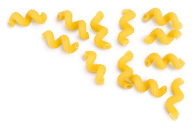 Çiğ makarna cavatappi, kesme yolu ve geniş bir alana yayılmış beyaz arka planda izole edildi. Metnin için kopyalama alanı olan üst görünüm. Düz yatıyordu.