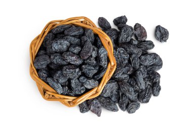 black raisins in wicker basket isolated on white background. Top view. Flat lay.