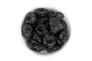 Beyaz arka planda izole edilmiş seramik kasedeki kuru erikler, bir yığın kuru erik. Üst Manzara. Düz yatıyordu.