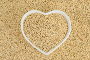 Arkaplan olarak seramik kasede beyaz kinoa tohumları. Üst Manzara. Düz yatıyordu.