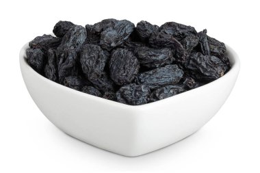 Beyaz arka planda izole edilmiş seramik kasedeki siyah kuru üzümler.