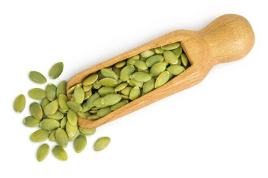 Soyulmuş kabak tohumları beyaz arka planda izole edilmiş ahşap kepçe. Üst Manzara. Düz yatıyordu.