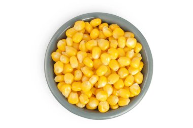 Beyaz arka planda izole edilmiş seramik kasedeki mısır tohumları. Üst Manzara. Düz yatıyordu.